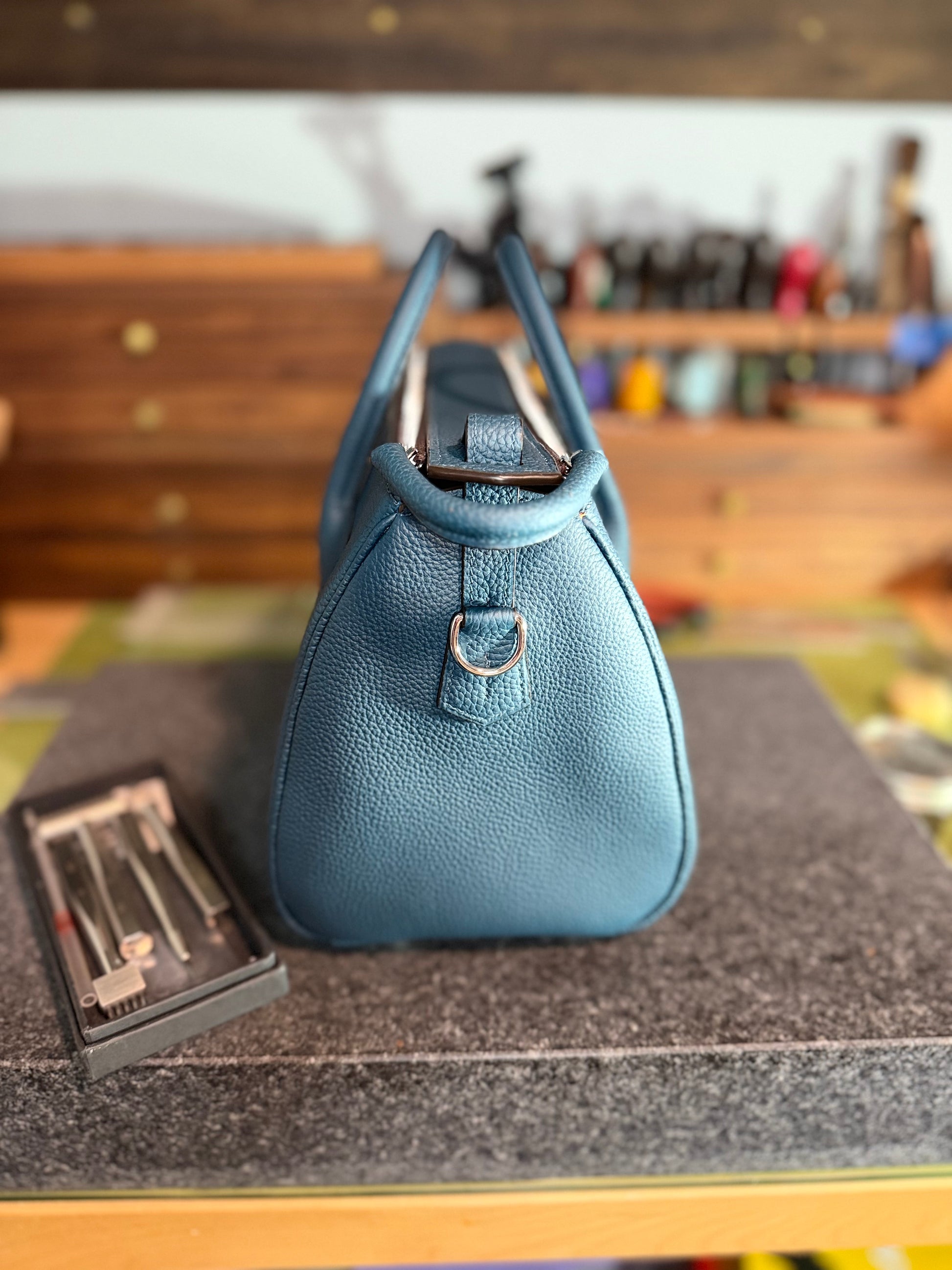 Blue handbag on a gray surface with a blurred background